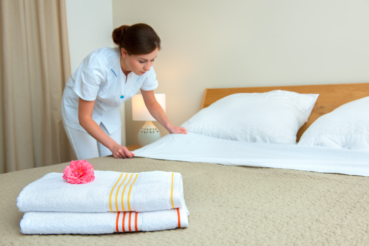 maid making hotel bed