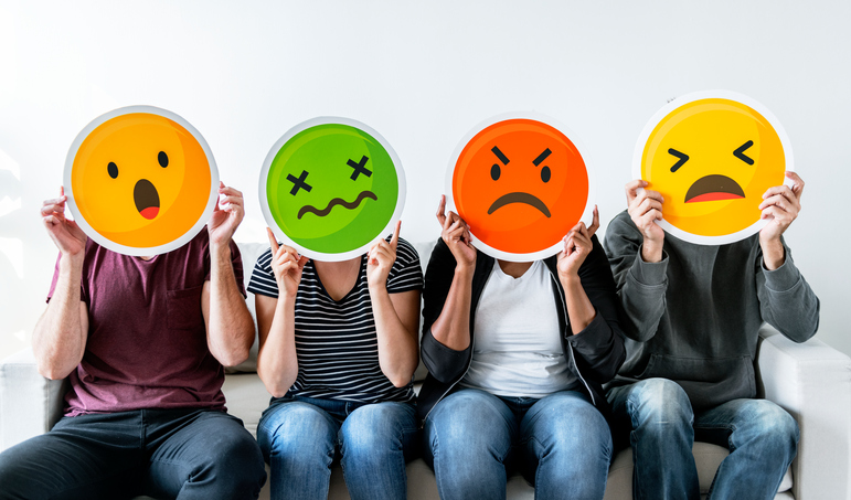 four people holding emoticons