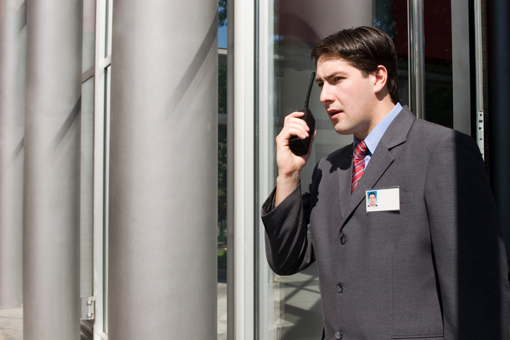 hotel security guard speaking into walkie talkie