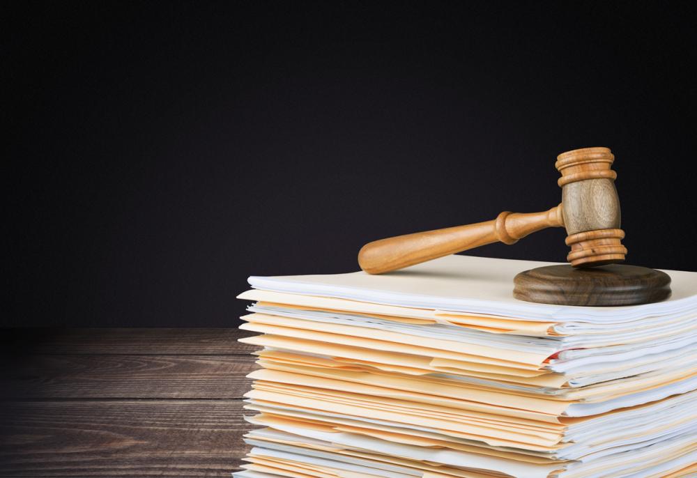 wooden gavel on stack of files