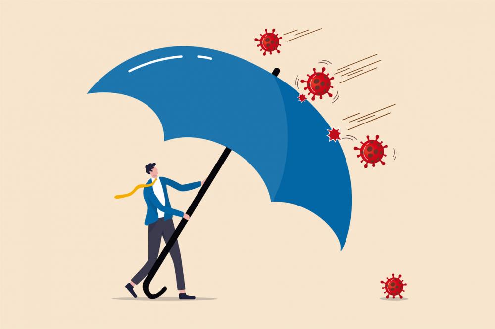 insurance concept: businessman holds off covid-19 bacteria with a large blue umbrella