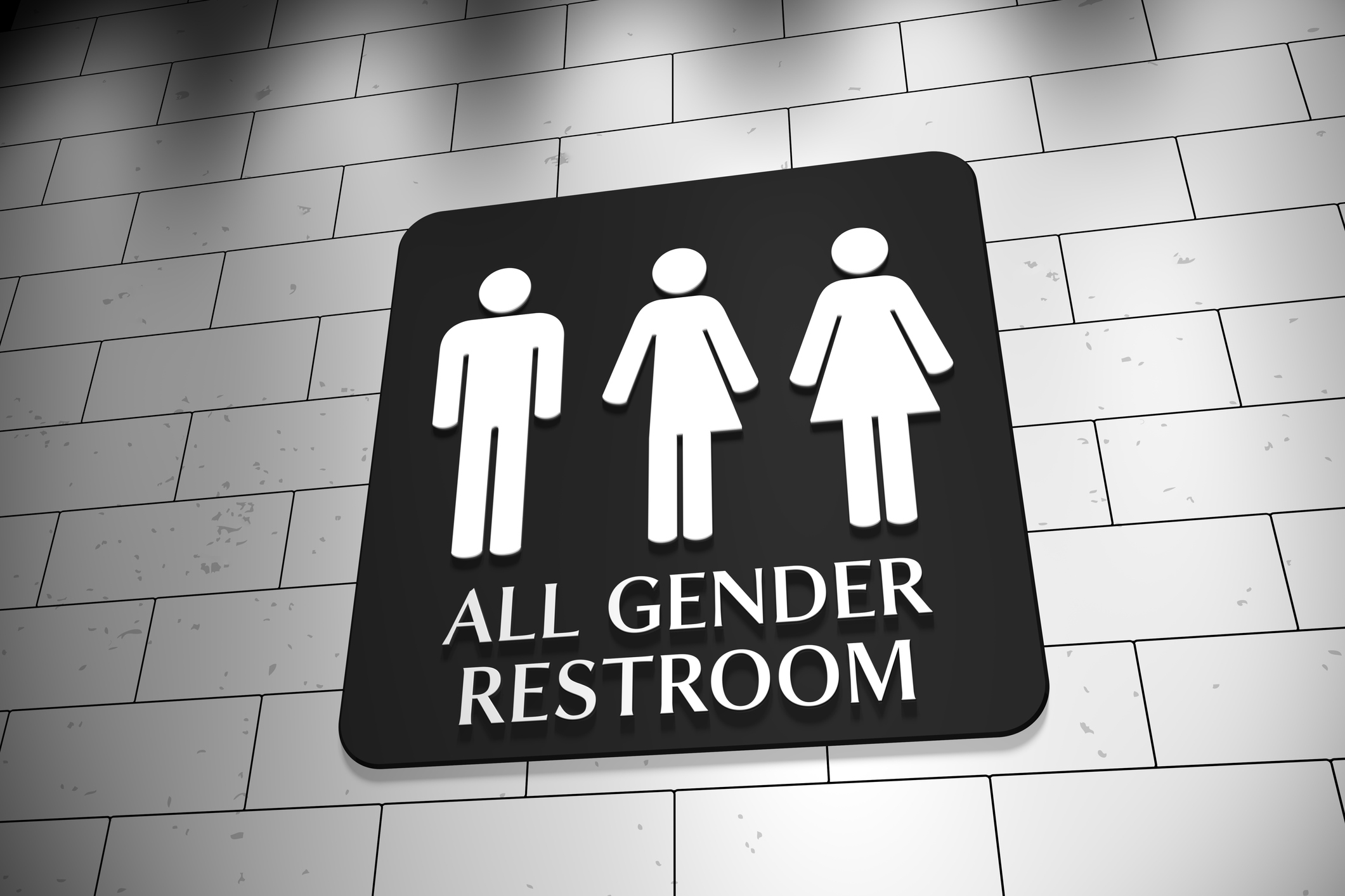 A sign on a wall for "All Gender Restroom" with symbols for men, trans and women