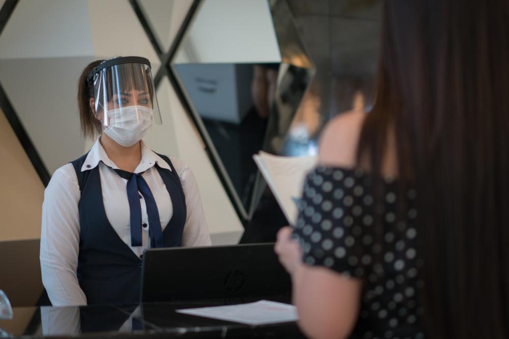 Receptionist wearing medical mask in office