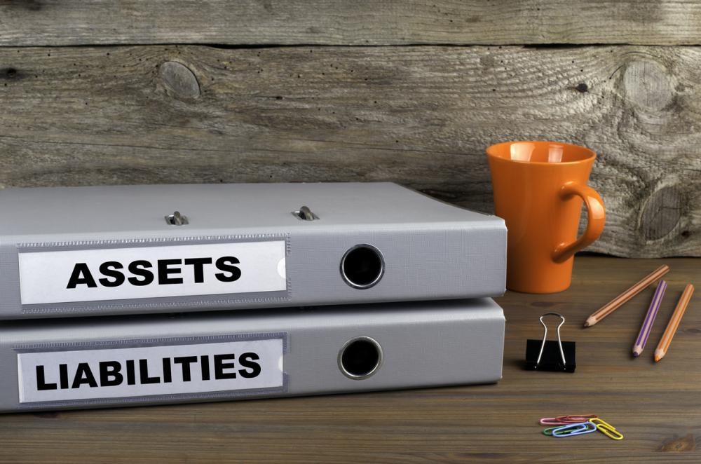 Assets and Liabilities - two folders on wooden office desk