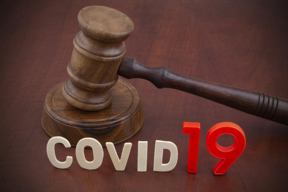 judge's gavel with letters spelling out COVID-19