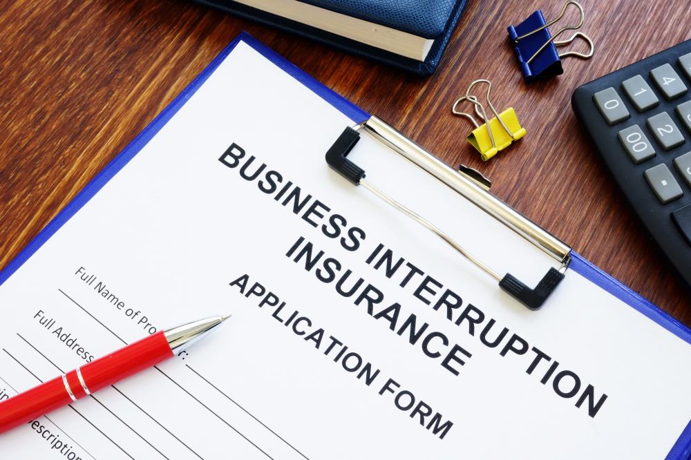 Business interruption insurance form and red pen for signing
