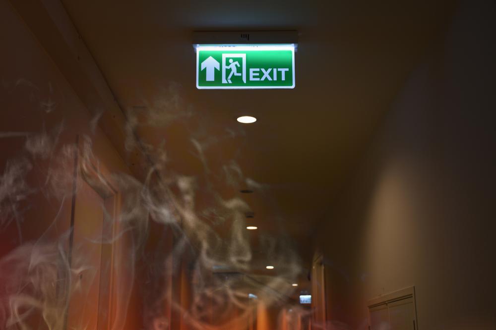 Emergency fire exit sign show the way to escape with the smoke