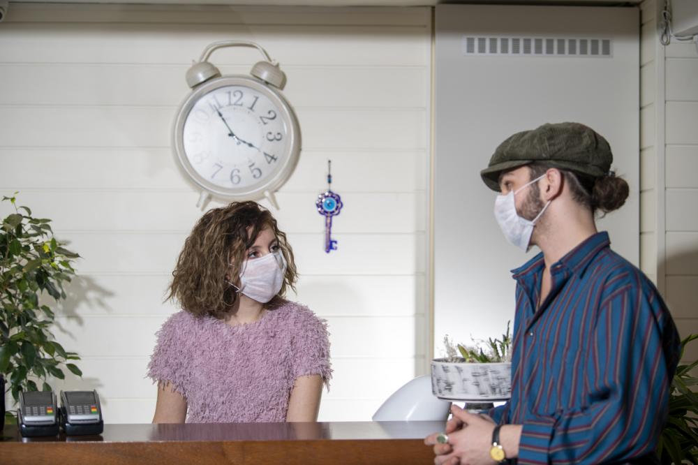 hotel concierge and guest both wearing face masks
