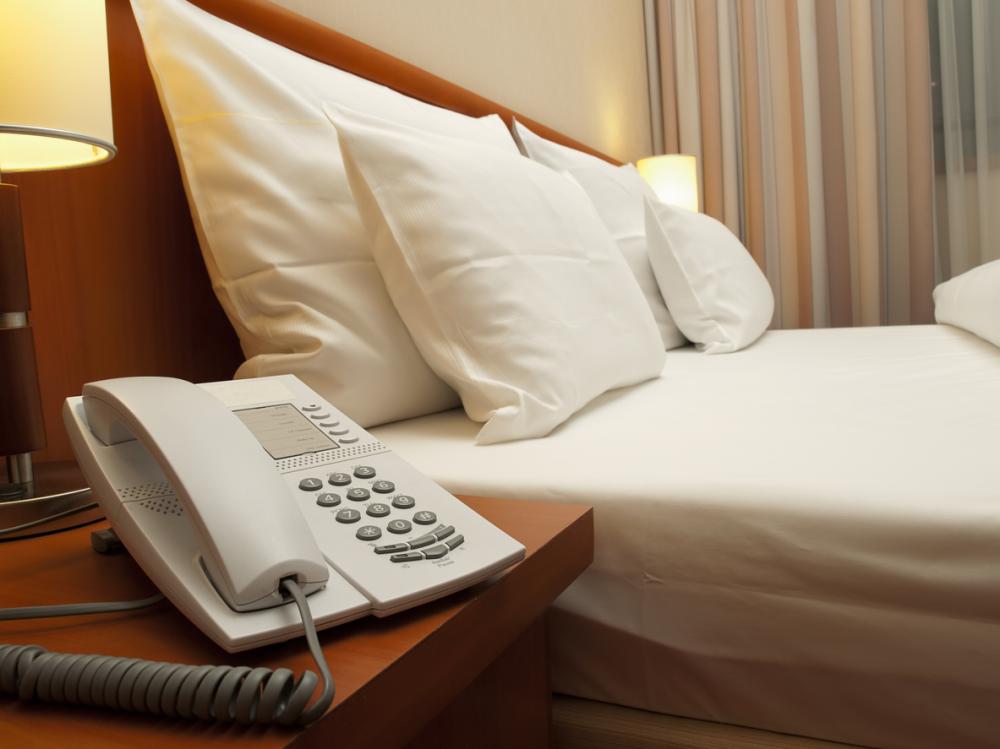 hotel bed and phone on bedside table