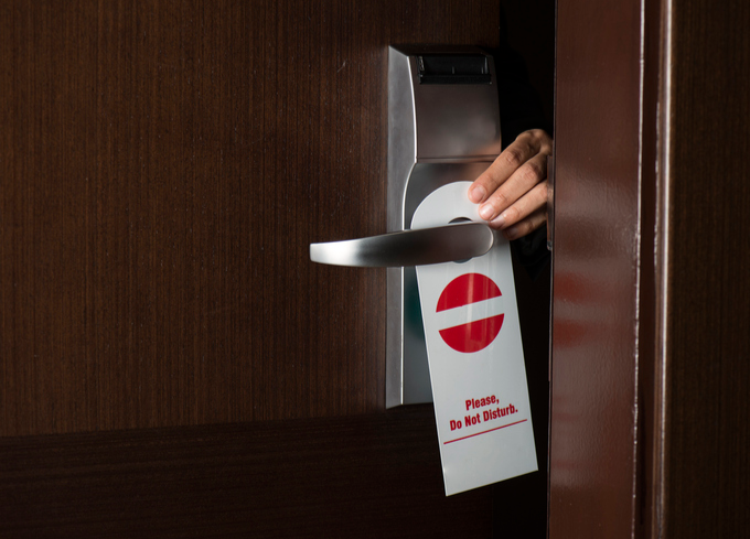 do not disturb sign being placed onto door handle