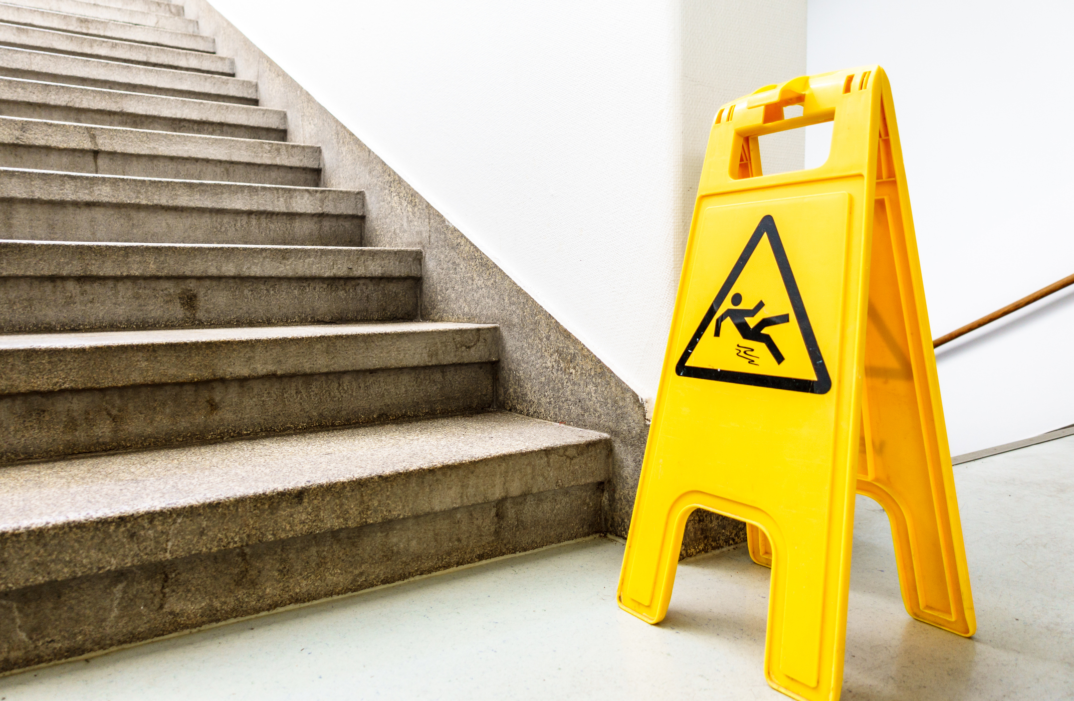 Yellow caution wet floor sign next to a staircase