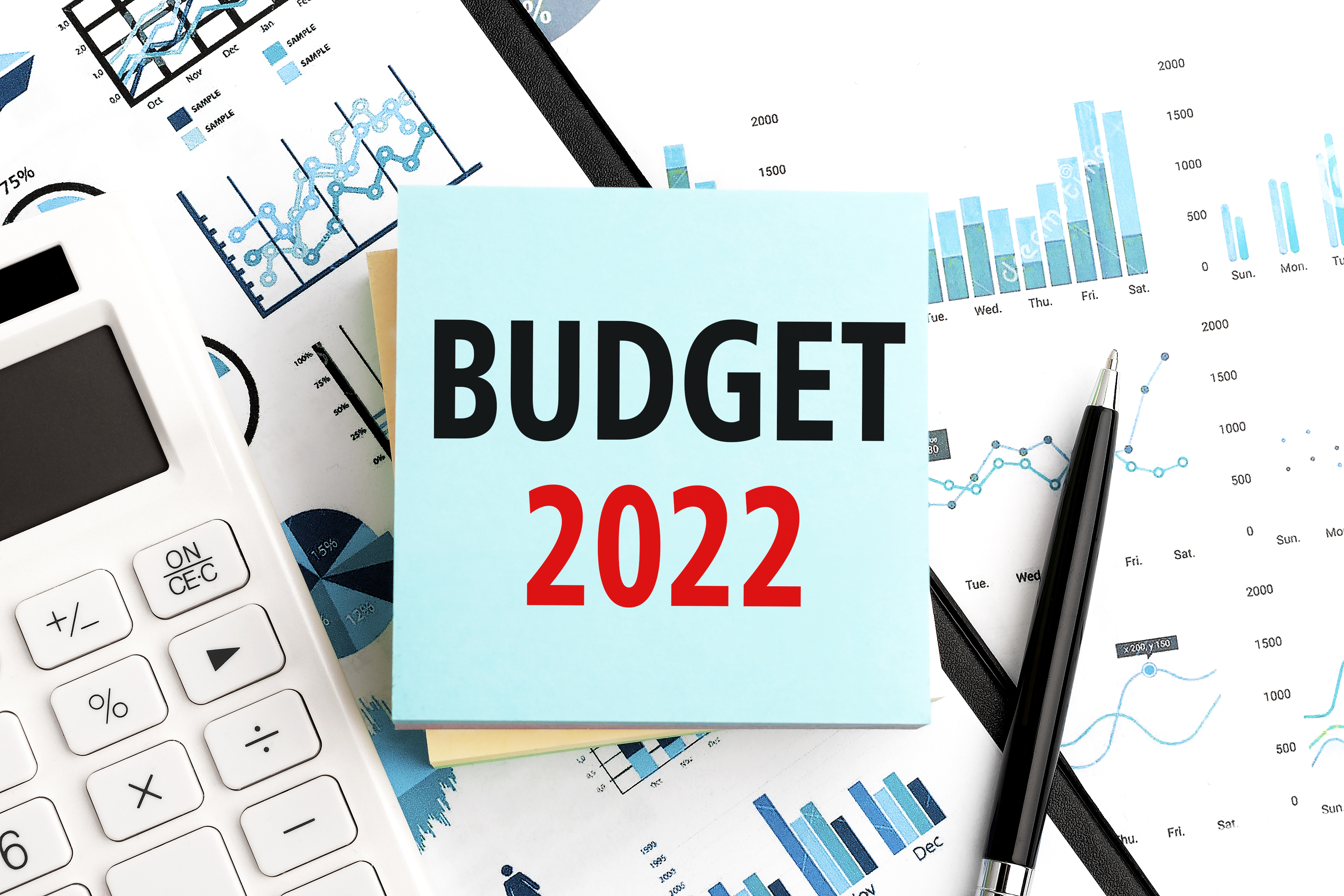 office supplies, calculator, financial papers, with notepad reading 'Budget 2022'
