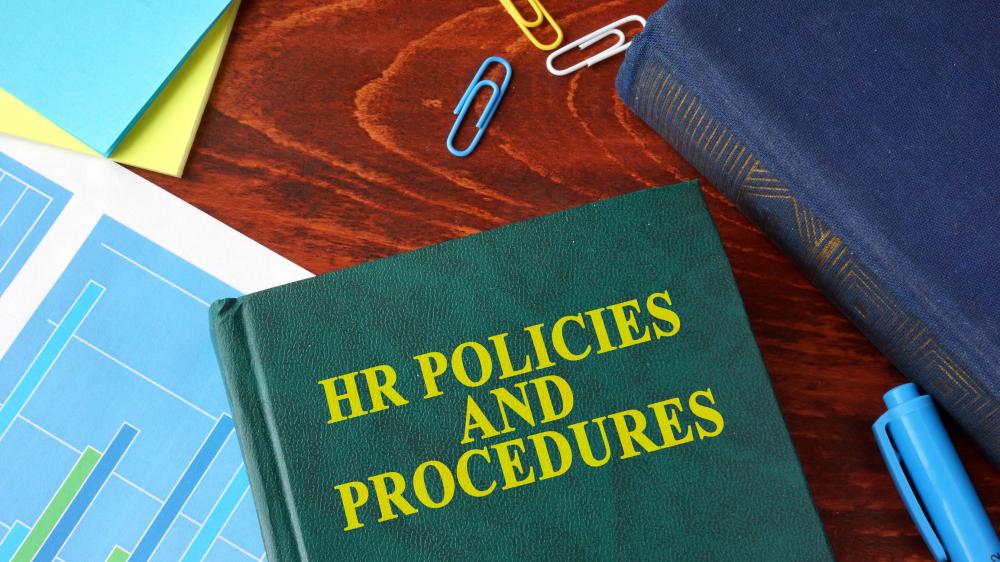 Book with title HR policies and procedures on a tabl