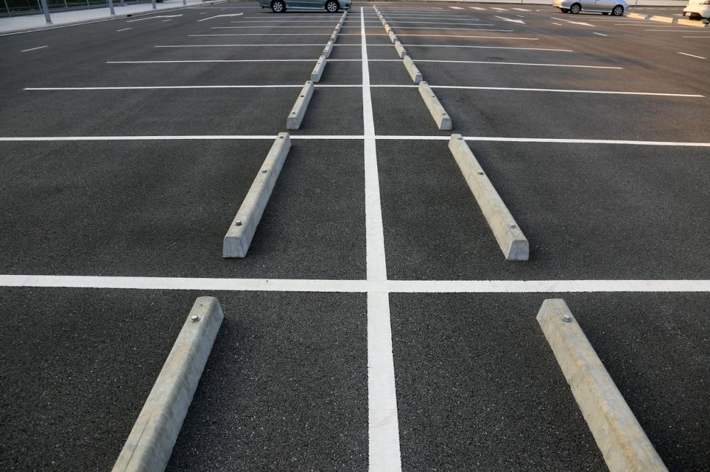 empty parking lot with white marking lines and curbs