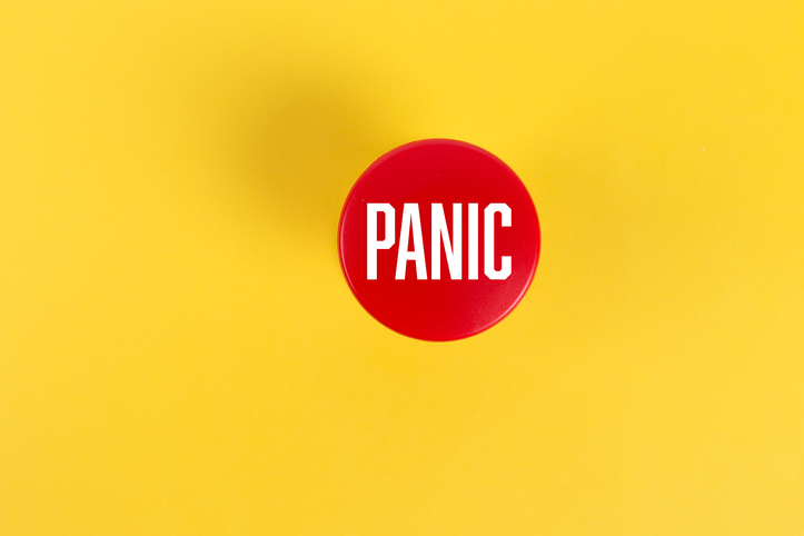 red panic button against solid yellow background