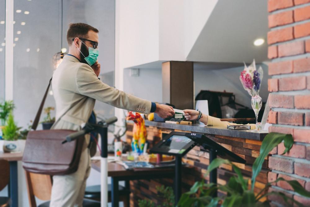 businessman wearing a face mask while he checks into hotel