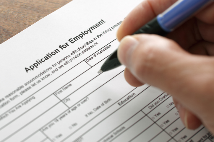 Close-up of a hand filling out a job application
